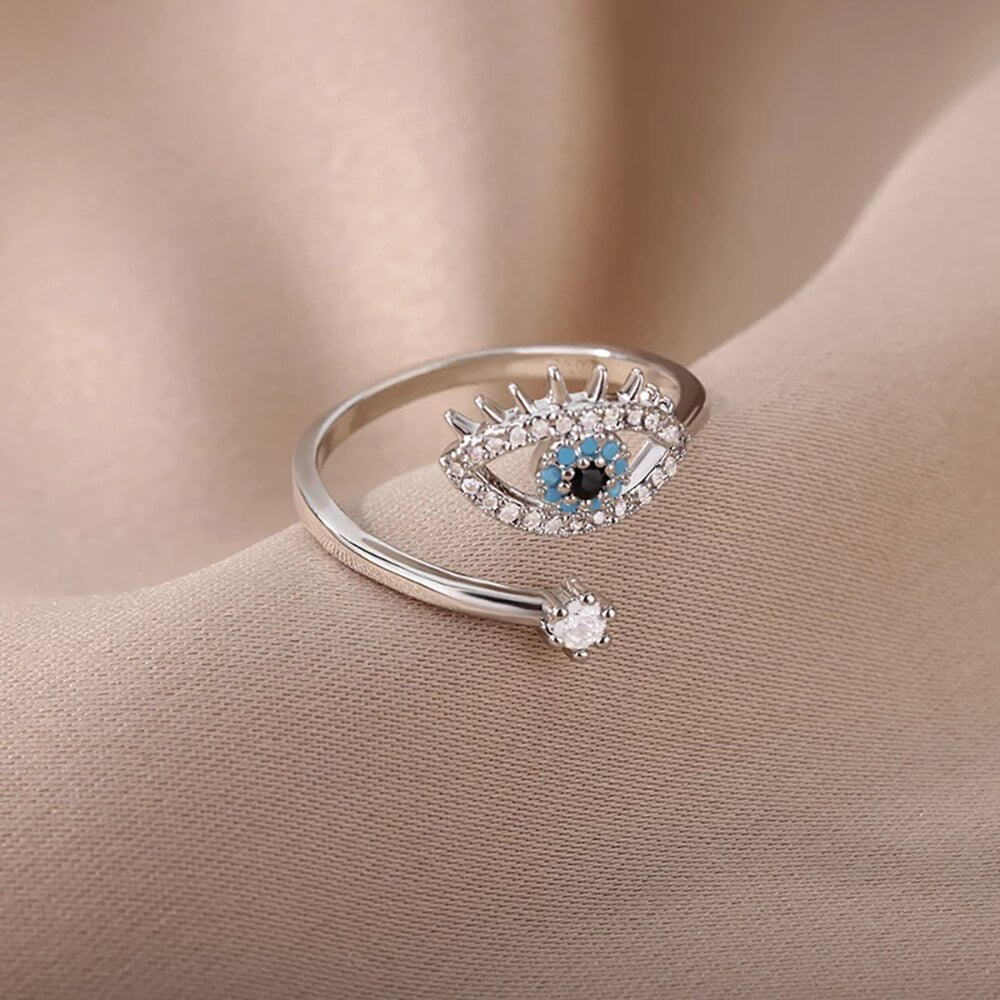 Nahaufnahme des verstellbaren Unisex-Rings Teufelsauge, aus Gold-Edelstahl mit funkelndem Zirkonstein.
