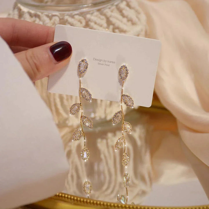 Elegante goldene Damen Blattohrringe im Blattdesign, als Tropfenohrringe getragen. Zarter Goldschmuck für Frauen.