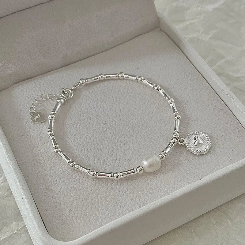 Elegantes Damenarmband aus Sterling Silber mit feinen Bambusdetails und glänzenden Perlen, ein stilvolles Accessoire.