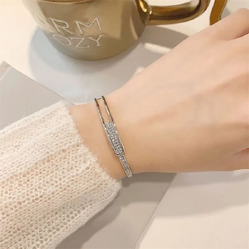 Funkelndes Damenarmband aus 925er Sterlingsilber mit Zirkonia-Besatz. Offen, verstellbar, stilvolles Accessoire.