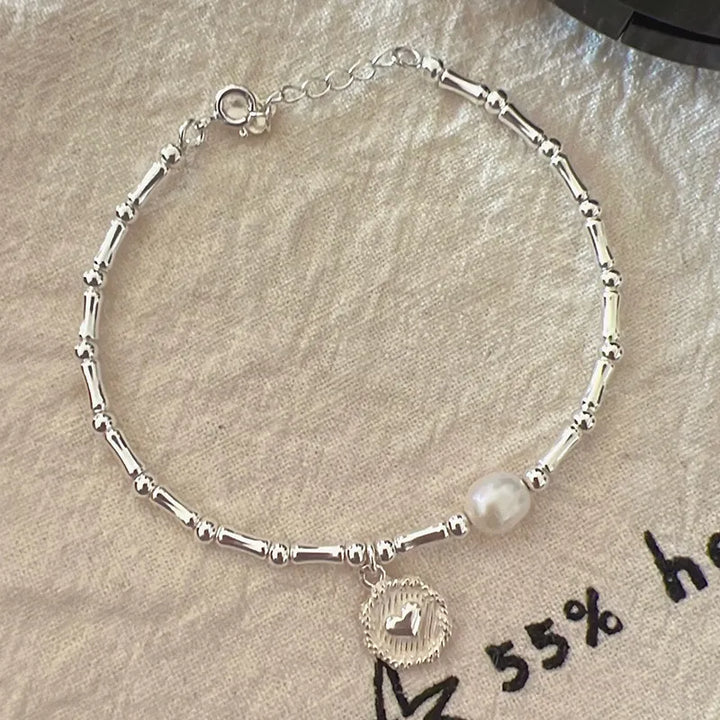 Modernes Silberarmband für Damen, mit einzigartigem Bambus-Design und zarten Perlen, perfekt als elegantes Geschenk.
