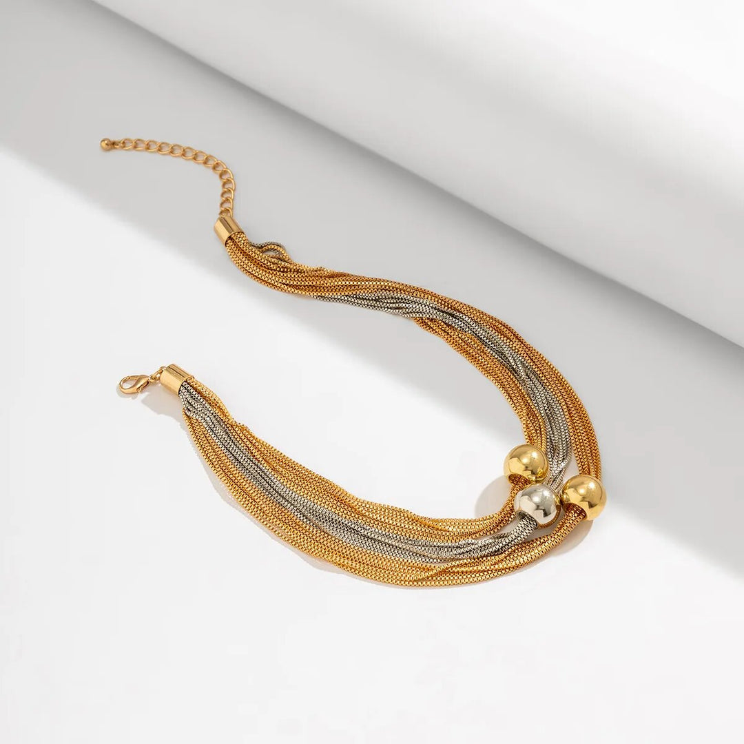 Dame trägt elegante Statement-Halskette mit großer Kugel und goldener Gliederkette aus Edelstahl. Modeschmuck.