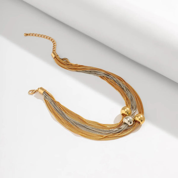 Dame trägt elegante Statement-Halskette mit großer Kugel und goldener Gliederkette aus Edelstahl. Modeschmuck.