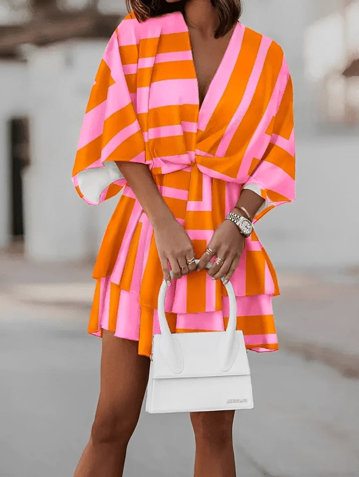 Verspieltes Damen Mini Kleid mit zartem Blumenmuster, angesagtem V-Ausschnitt & weiten Kimono-Ärmeln.