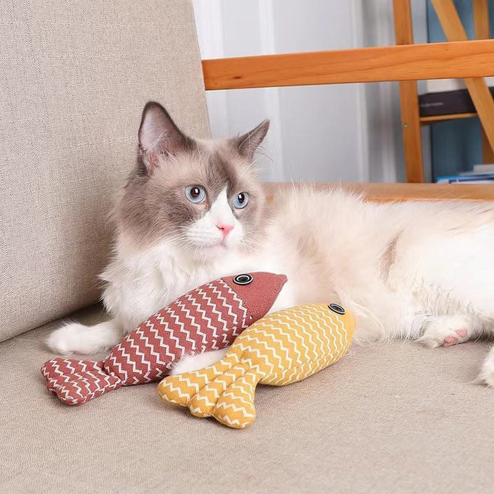 Glückliche Katze spielt begeistert mit interaktivem Fischspielzeug gefüllt mit anregender Katzenminze, für puren Spielspaß.