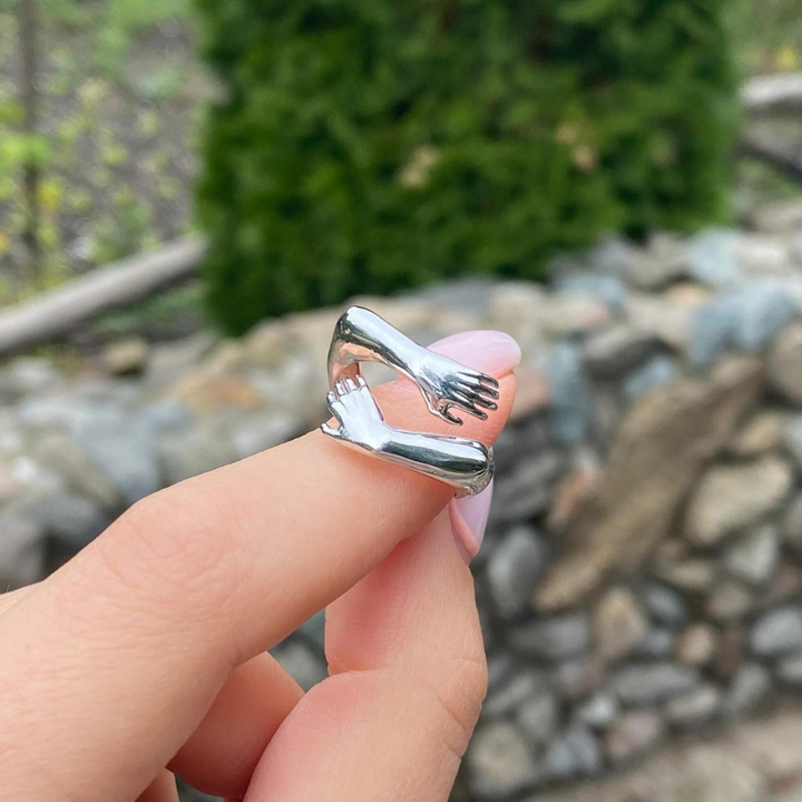 Silber Umarmungsring als Liebesgeschenk, symbolisiert Ewigkeit und Verbundenheit.