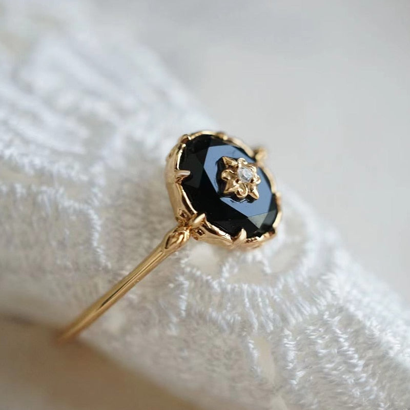 Nahaufnahme des Vintage-Damenrings: Ovaler Achat-Edelstein, umrahmt von glänzenden Zirkonen auf schimmerndem Silber.