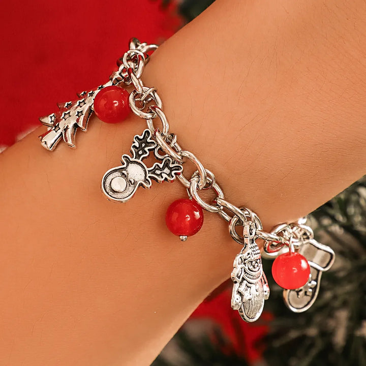 Silbernes Damenarmband mit festlichen Charms: Schneeflocken, Glöckchen und Bäume, ideal für Weihnachten.