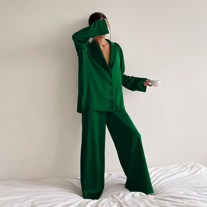 Frau trägt elegantes Damen Pyjama Set als komfortable Loungewear, entspannt auf dem Sofa im Hausanzug.