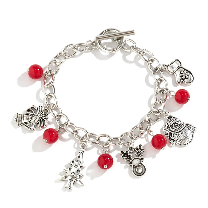 Festliches Damen Charme-Armband aus Silber mit winterlichen Anhängern wie Schneeflocken & roten Perlen.