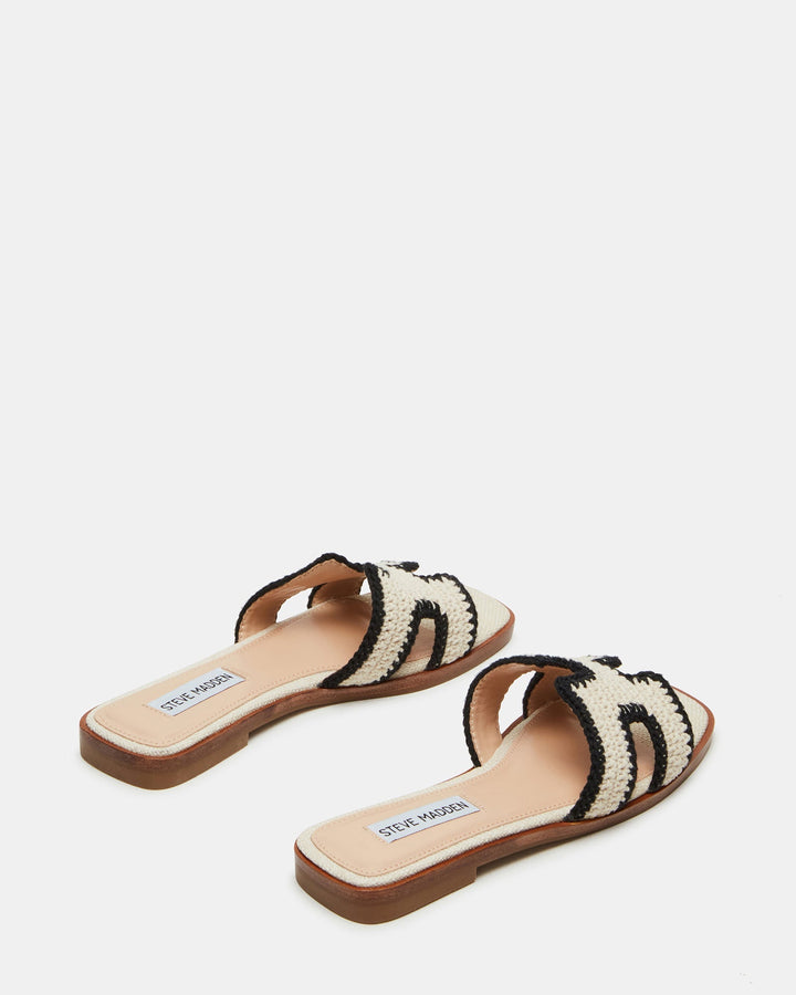 Sommerliche Damen-Pantolette mit breitem, geometrischem Riemen und bequemem Flachabsatz.