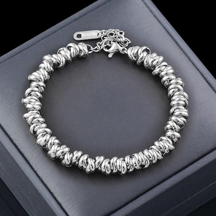 Nahaufnahme des Damenschmuck Kettenarmbands mit runden goldenen Perlen und feinen Kettengliedern.