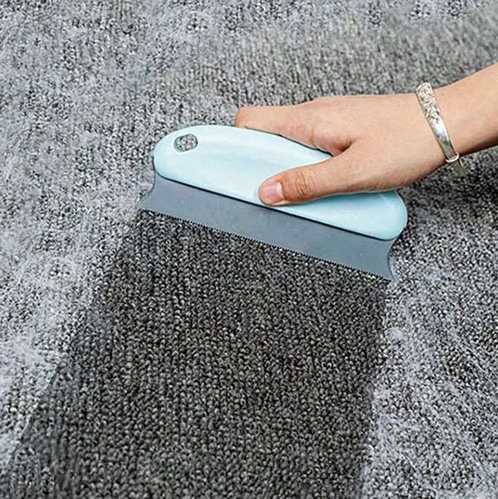 Praktischer Tierhaarentferner neben spielender Katze. Hält Haushalt sauber von Tierhaaren auf Sofa & Teppich.