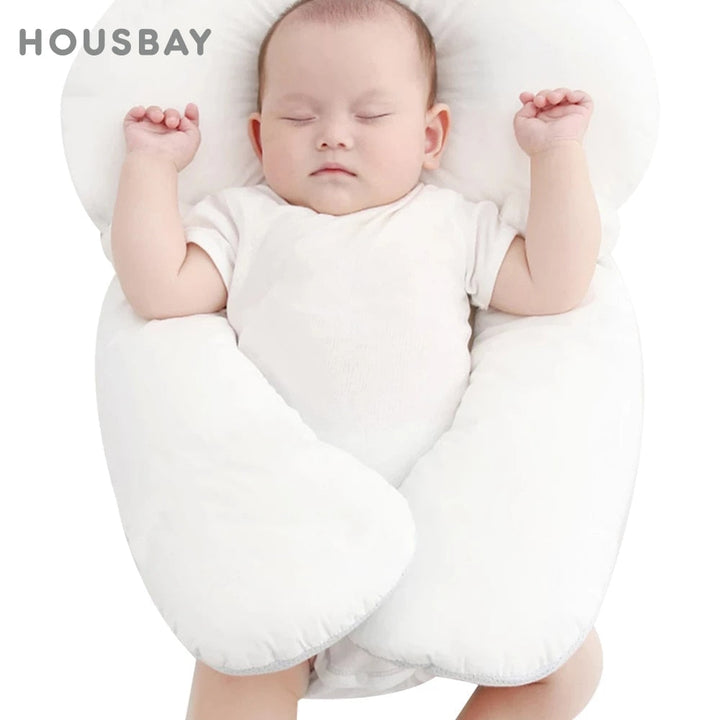 Baby auf atmungsaktivem Bio-Baumwoll-Lagerungskissen, gemütlich & sicher, fördert gesunden Babyschlaf.
