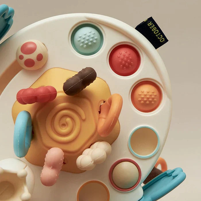 Buntes sensorisches Kinder Ufo mit Zugseilen. Ideales Baby Spielzeug zur Förderung der Feinmotorik beim Zahnen.