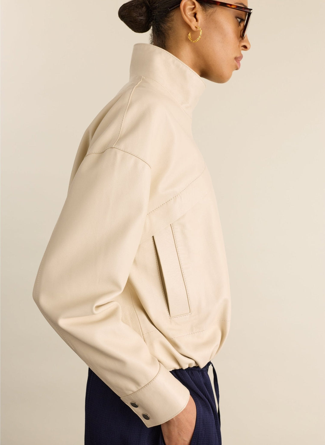 Model trägt vielseitige kalkweiße Damen Bomberjacke mit Stehkragen, ideal für einen modernen, lässigen Look.