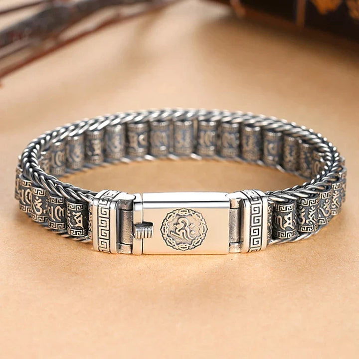 Nahaufnahme des buddhistischen Armbands mit detailreicher Om Mani Padme Hum Gravur; Glücksbringer Schmuck.