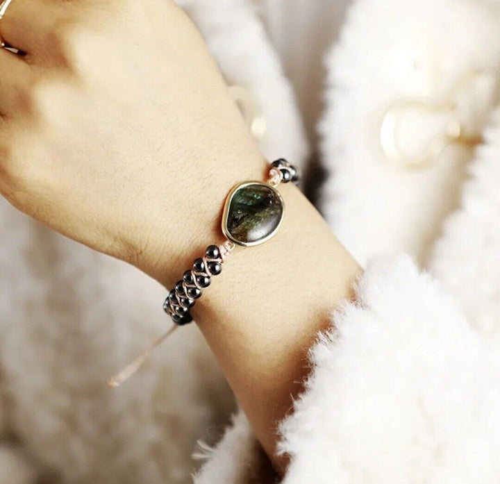 Nahaufnahme: Geflochtenes Manschettenarmband aus glänzenden Onyx- & Hämatit-Natursteinen, unisex Schmuckdetail.