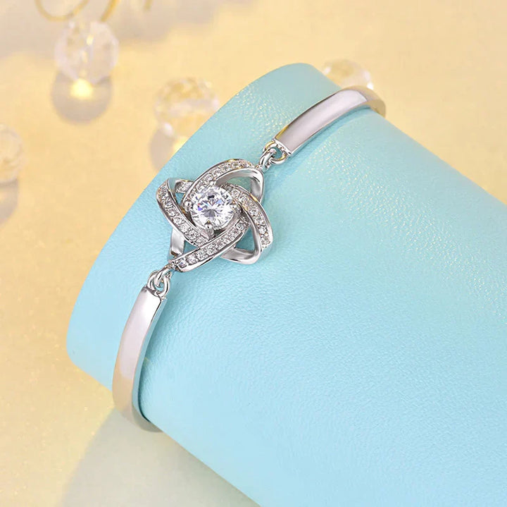 Elegantes Damen Liebesknoten Armband aus Edelstahl mit funkelnden Zirkonia Steinen, verstellbar, perfekt als Geschenk.
