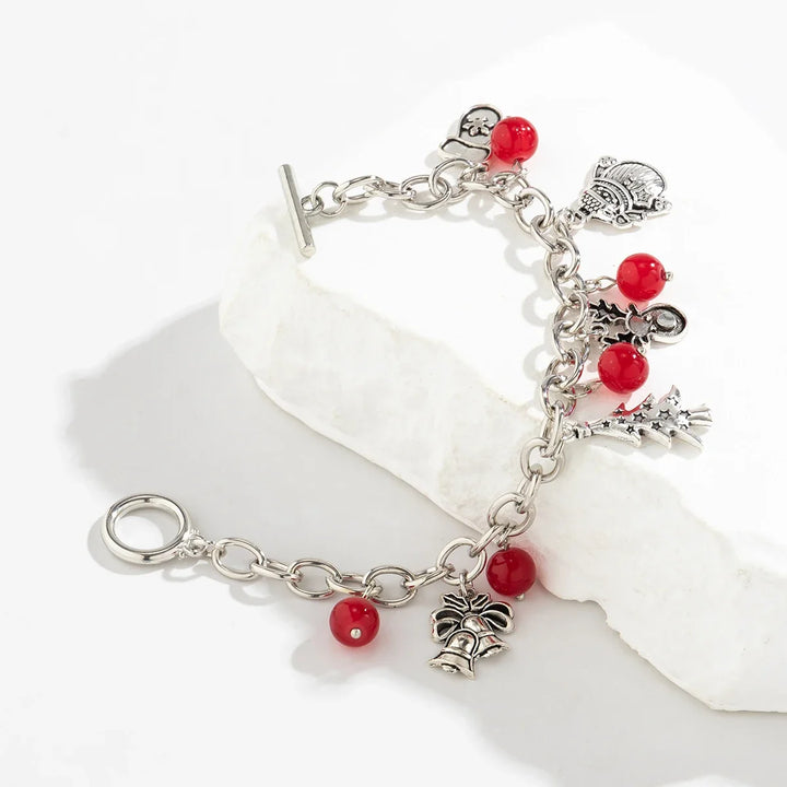 Winterliches Silberarmband für Damen mit roten Perlen und festlichen Weihnachts-Charms. Perfekt als Geschenk.