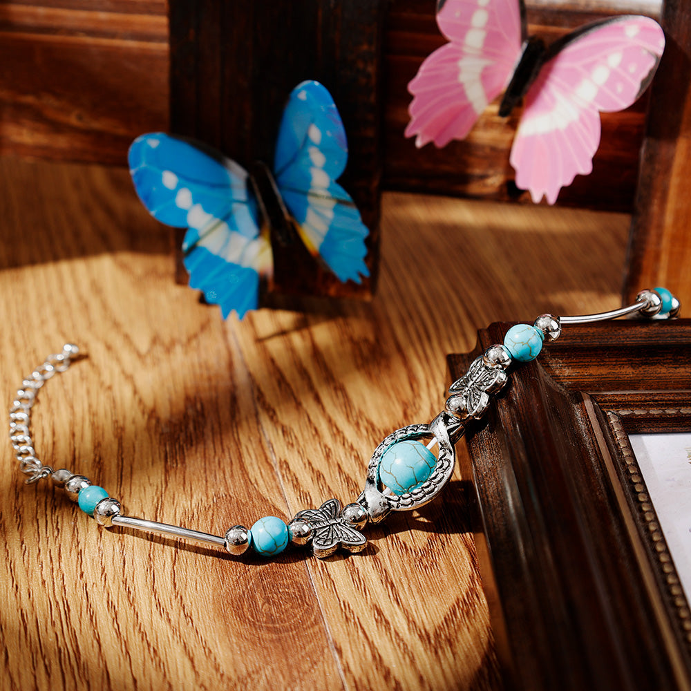 Damen Perlenarmband mit echten Türkisperlen und filigranem Schmetterlings-Anhänger für Natur-Liebhaberinnen.