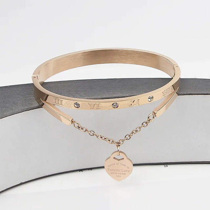 Detailaufnahme: Glänzender Unisex-Liebesarmreif aus Edelstahl mit funkelndem Zirkon-Herzanhänger.