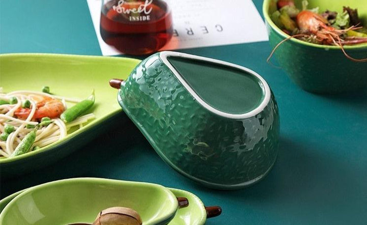 Dekorative Avocado Keramik Schüssel auf Holztisch, ästhetisches Designobjekt, grüne Akzente für Zuhause.
