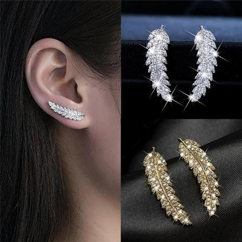 Glänzende Goldohrringe für Damen mit filigranem Engelsflügel-Motiv. Spiritueller Schmuck, ideales Geschenk.