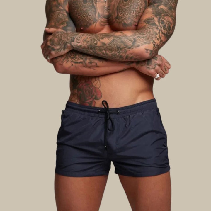 Mann trägt stilvolle, schnelltrocknende Herren Badehose beim Entspannen am Pool im Sommerurlaub.
