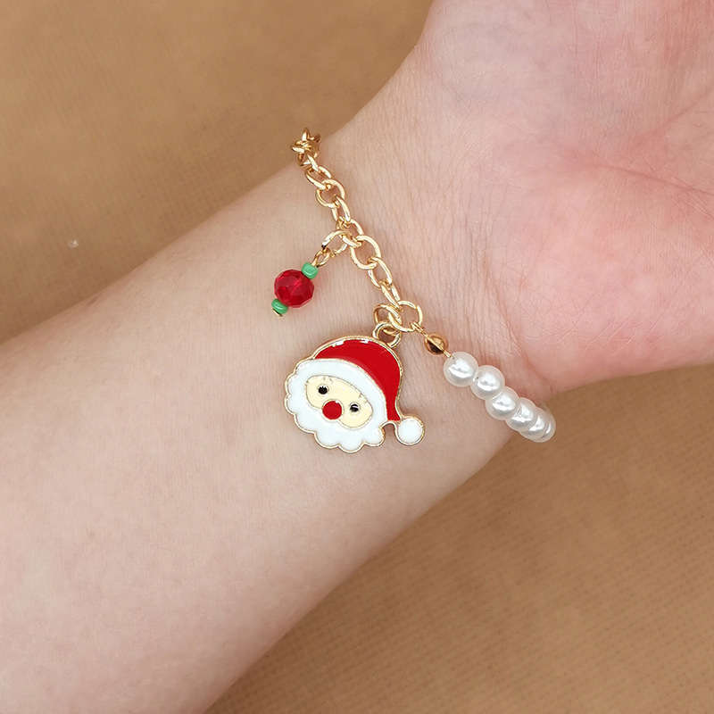 Festliches Damen Charm-Armband mit weißen Perlen & Weihnachtsanhängern. Ideales Winter Accessoire.