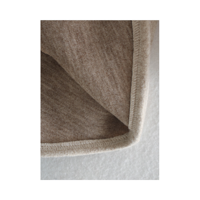 Nahaufnahme des Kragens und Stoffes eines eleganten beigen Damen-Übergangsmantels.