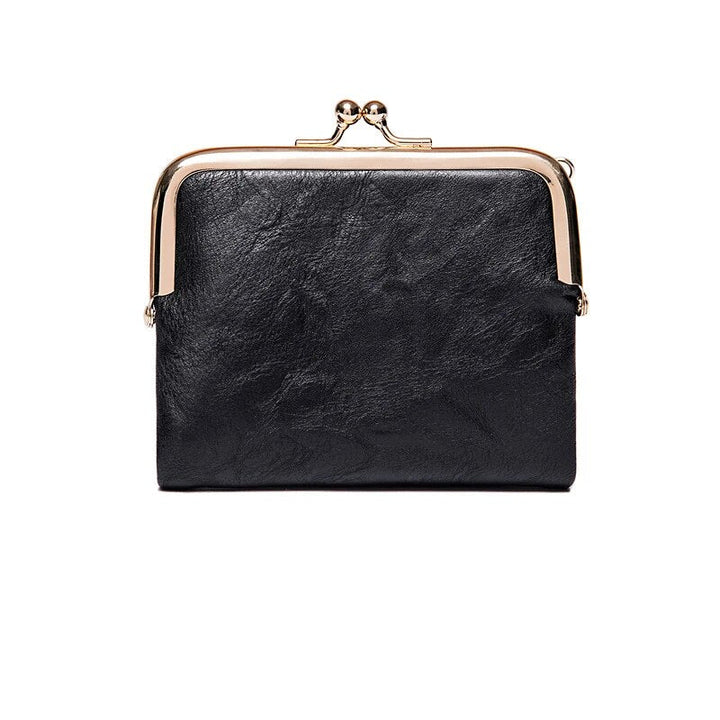 Geöffnete kurze Damen Vintage Brieftasche, Kussverschluss, zeigt Fächer für Karten und Münzen.