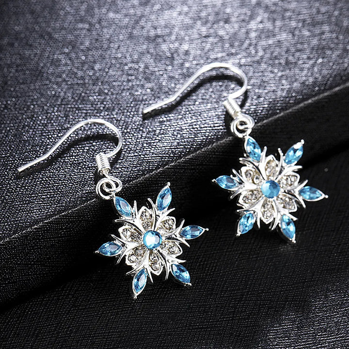 Festliche Damen-Ohrringe, Schneeflocken-Design mit leuchtend blauen Strasssteinen. Ideal für Weihnachten.
