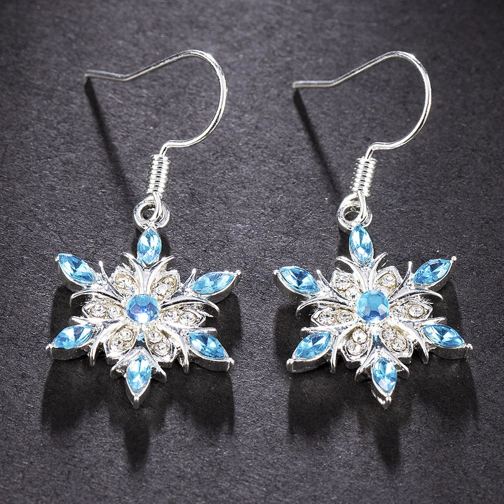 Elegante Damen-Ohrringe im Schneeflocken-Stil mit funkelnden blauen Strasssteinen. Winterschmuck.