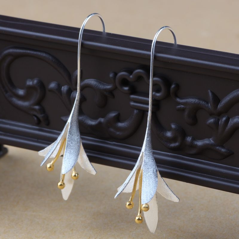 Model trägt funkelnde lange Blumenohrringe aus 925er Sterlingsilber, Damenschmuck.