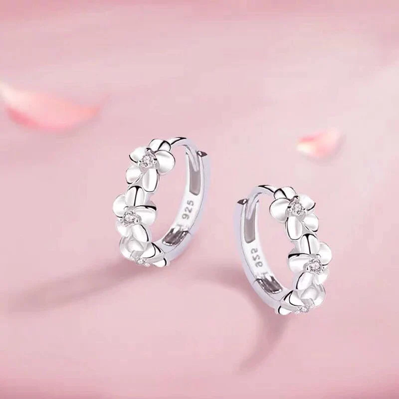 Nahaufnahme von zarten Silber Blumenohrringen mit detailreichen Anhängern, ideal als elegantes Accessoire.