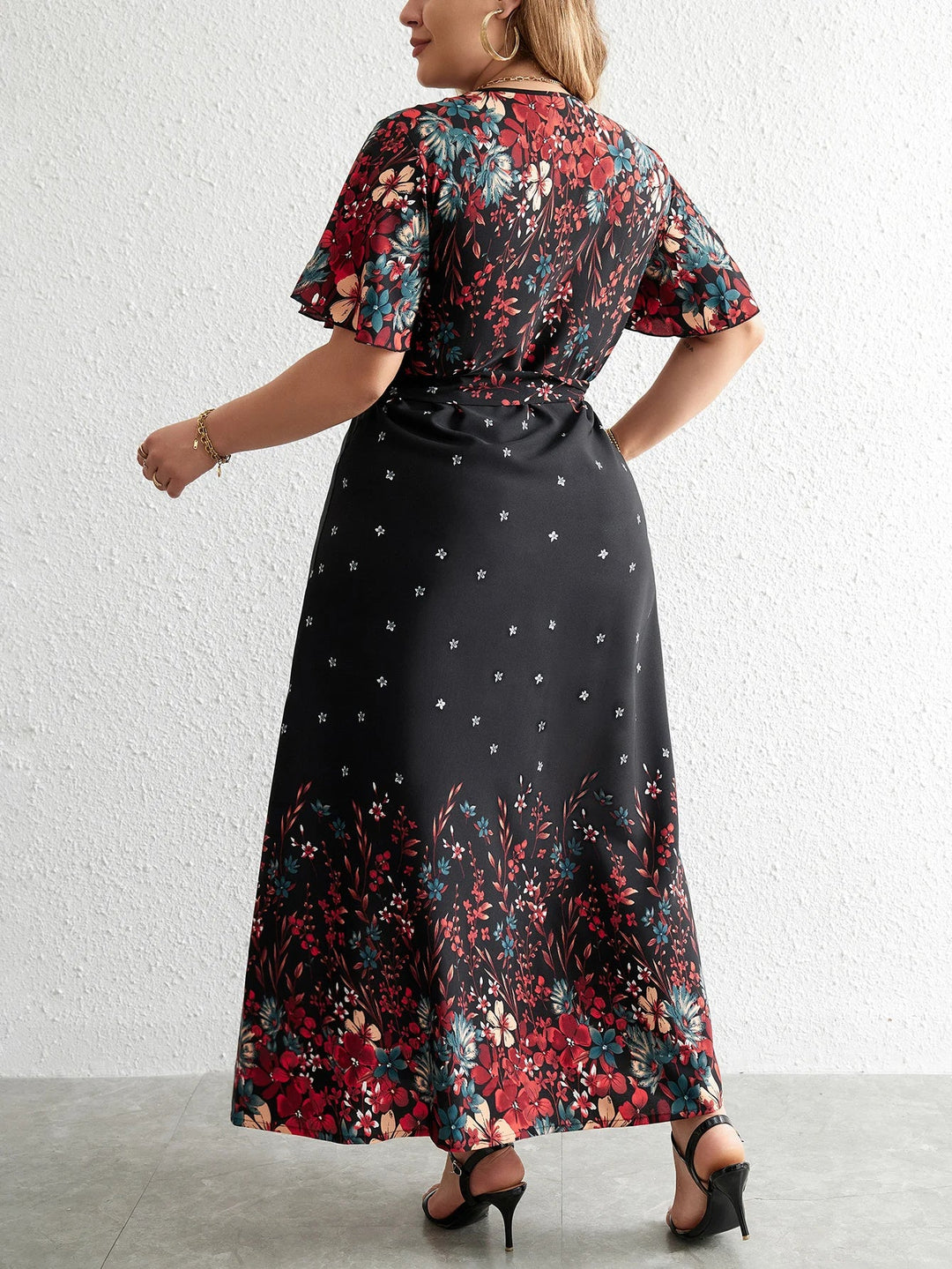 Plus-Size Model trägt modisches Damen Blumen Maxikleid Übergröße, V-Ausschnitt, Kurzarm, Freizeitkleid, elegant & herbstlich.