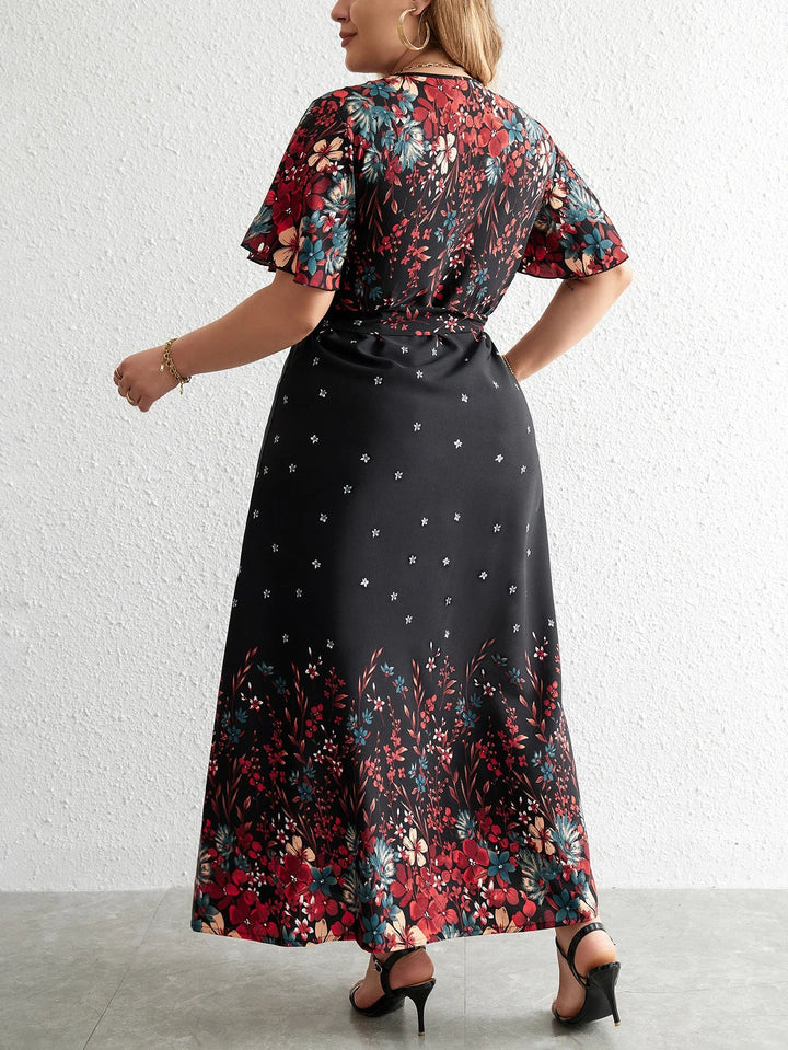 Plus-Size Model trägt modisches Damen Blumen Maxikleid Übergröße, V-Ausschnitt, Kurzarm, Freizeitkleid, elegant & herbstlich.