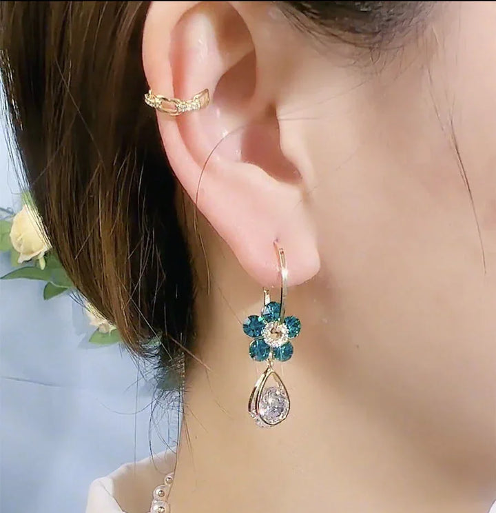 Modische Damen Ohrringe mit funkelnden Kristallen & floralem Design. Eleganter Blumenschmuck für Frauen.