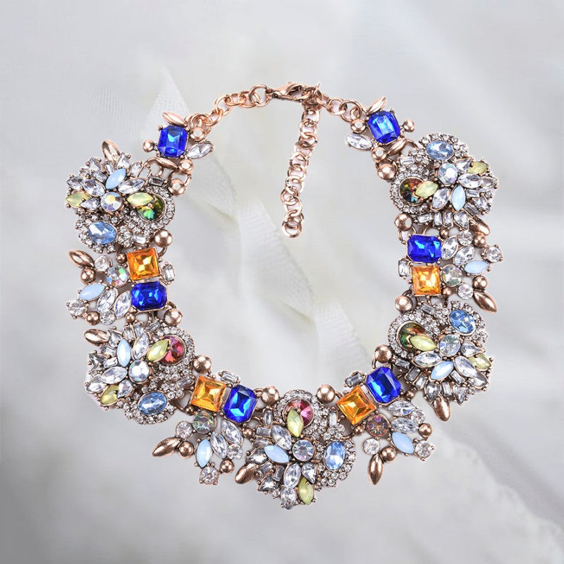 Boho-Damenhalskette mit blauer Blume und funkelnden Kristallen. Eleganter Modeschmuck im Bohemia-Stil, verstellbar.