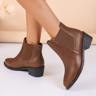Seitenansicht der eleganten braunen Chelsea-Stiefeletten für Damen, mit Blockabsatz und Profilsohle.