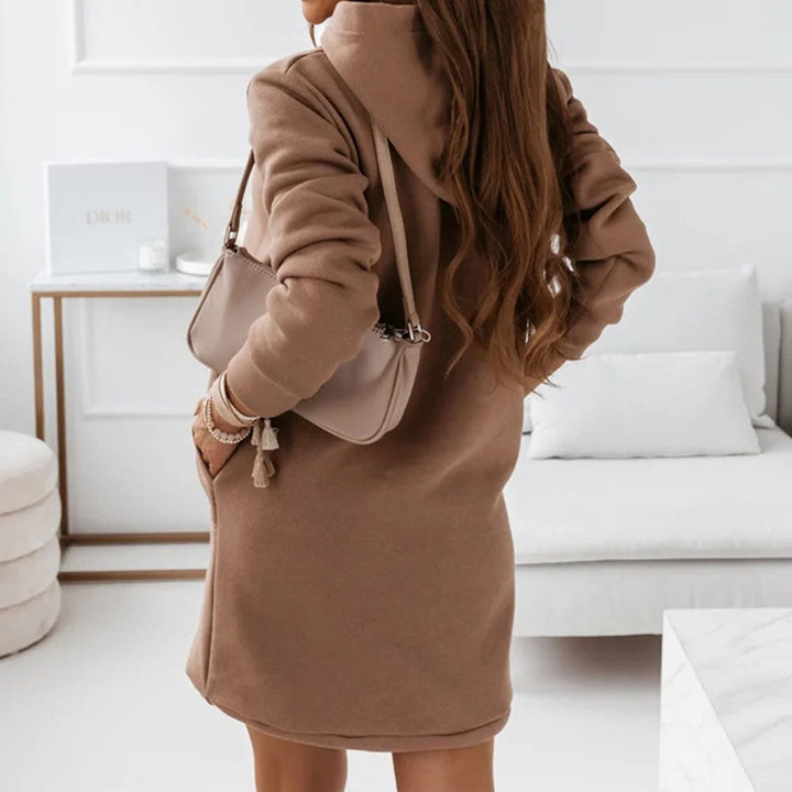 Frau trägt stilvolles, weiches Damen Hoodie-Kleid. Modisches Freizeitkleid, ideal für entspannte Herbsttage.
