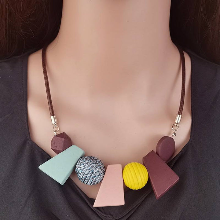 Geometrische Ethno-Halskette aus Holzperlen, handgefertigter Damenschmuck im Vintage-Boho-Look.