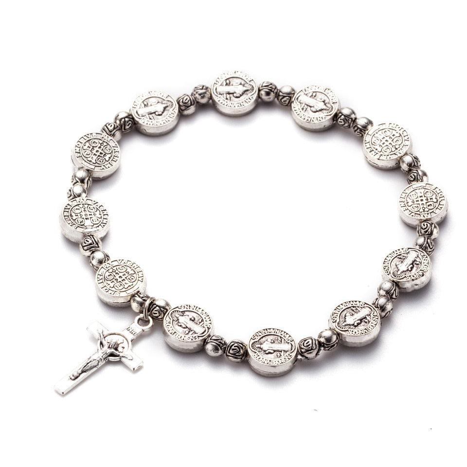 Modernes unisex Kreuzarmband am Handgelenk, glänzende Gold- und Silberfarben, stilvolles christliches Accessoire.