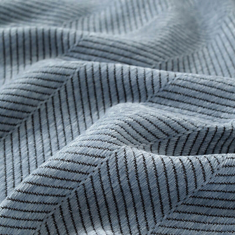 Nahaufnahme des Fischgrätenmusters auf dem weichen Chenille Sofabezug mit Quastendetail.