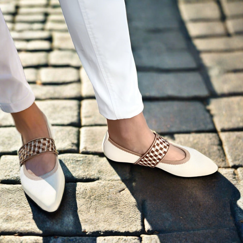 Damenfüße in eleganten Ballerinas mit spitzer Zehe, bequeme Sommerschuhe für stilvolle Auftritte.
