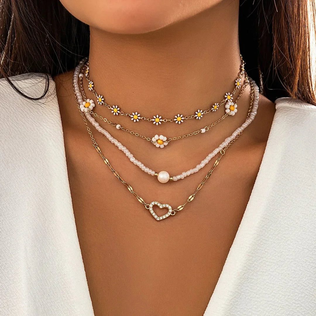 Mehrreihiges Damen Schmuckset: Boho Ketten mit Gänseblümchen-Anhängern und zarten Perlen.