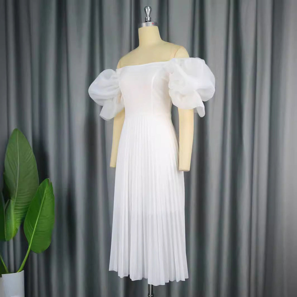 Festliches Damen-Cocktailkleid mit zarten Puffärmeln und elegantem Plisseerock für besondere Feiern.