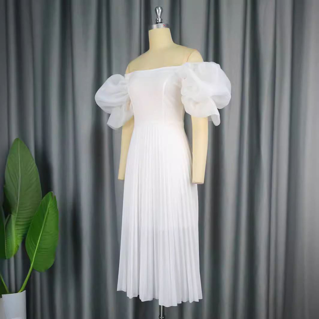 Festliches Damen-Cocktailkleid mit zarten Puffärmeln und elegantem Plisseerock für besondere Feiern.