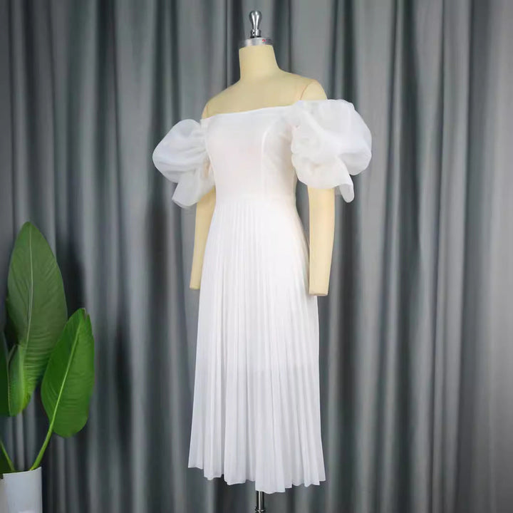 Festliches Damen-Cocktailkleid mit zarten Puffärmeln und elegantem Plisseerock für besondere Feiern.